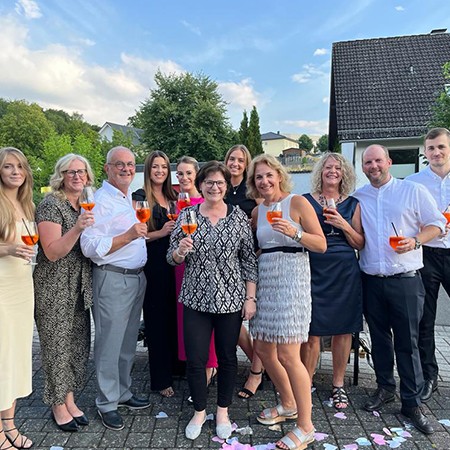Gruppenfoto im Sommer, die Personen haben ein Glas Aperol in den Händen